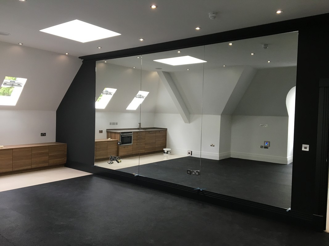 Frameless glass wall dividing loft conversion in Camberwell